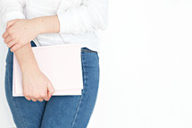 a woman holding a pink notebook 