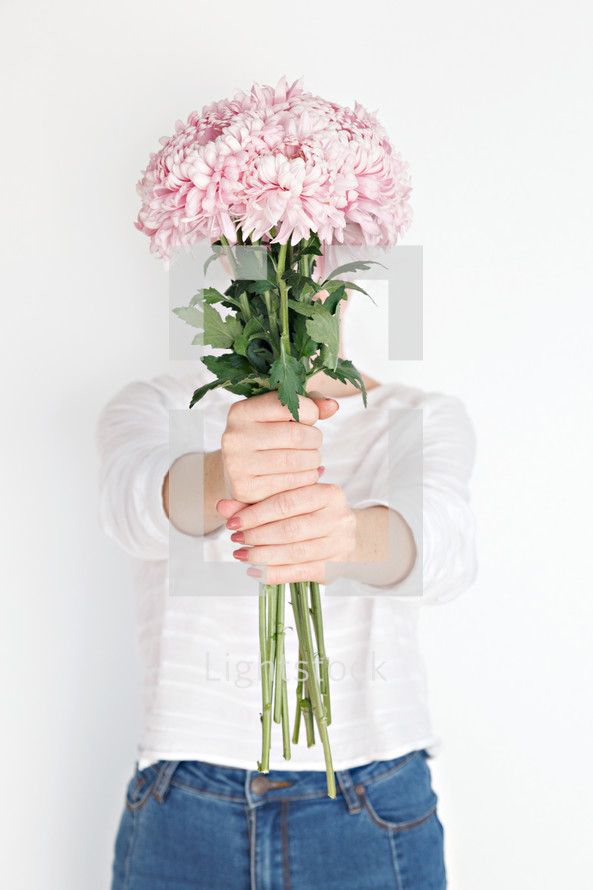 a woman holding a bouquet of pink flowers 