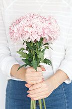 a woman holding a bouquet of flowers in front of her 