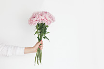 a woman holding a bouquet of pink flowers 