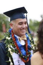 A smiling graduate wearing a Hawaiian leis