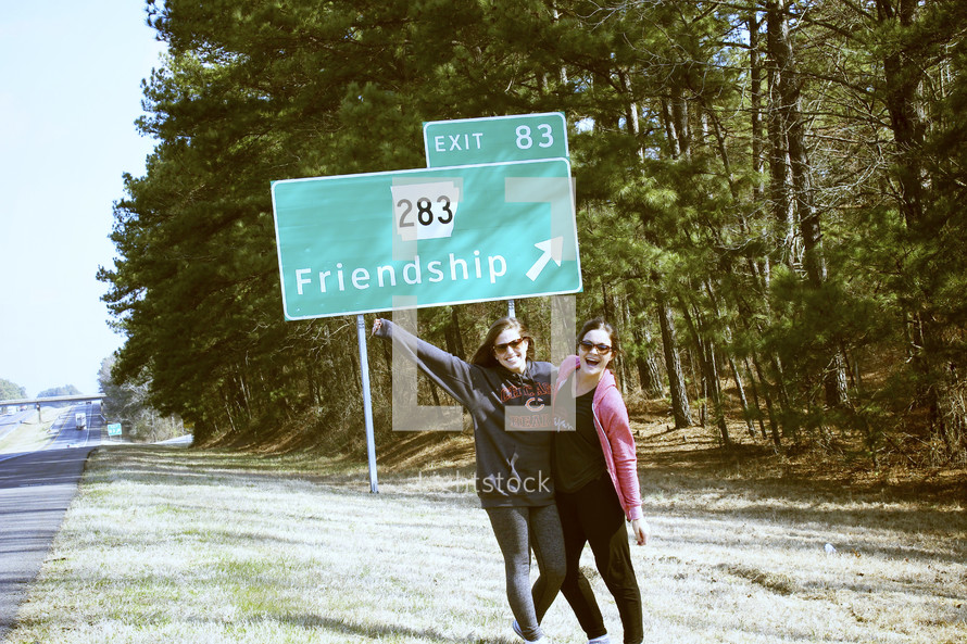friends in front of a friendship street sign 