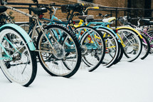 bicycles parked on a bike rack in the snow 