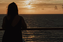 silhouette of a woman standing on a cruise ship 