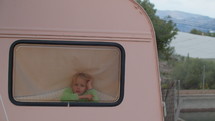 Young girl looking out the window of a camper van
