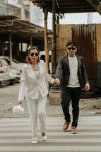 bride and groom walking in a city 