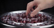 Dolly shot of a person picking up a communion cup from a silver tray.