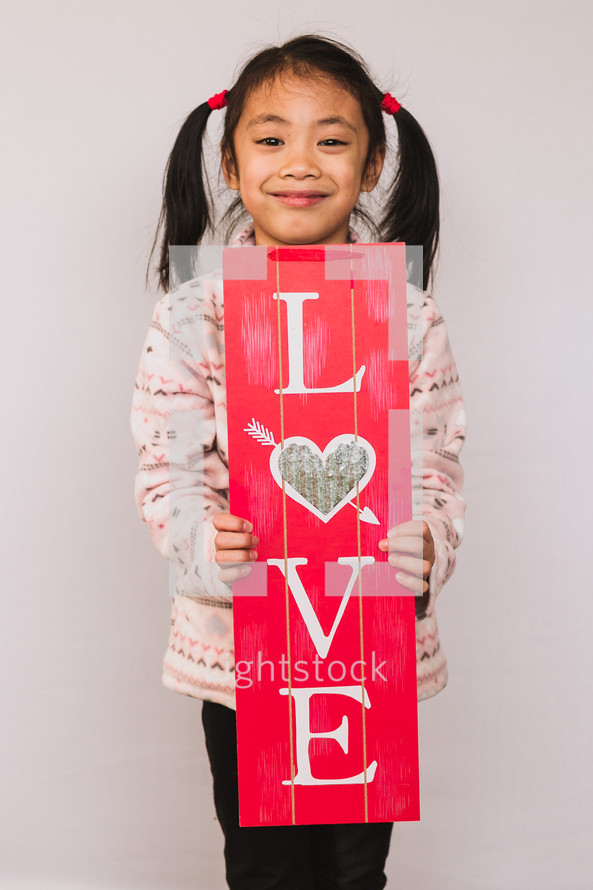 A child holding a love sign 