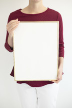 a woman holding a blank white board 