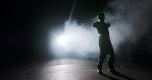 Teenage female dancer performing hip hop dance in slow motion with strobe light and smoke background