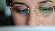 Young woman with glasses working on a digital tablet computer - close-up