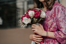 a woman holding a bouquet of roses 