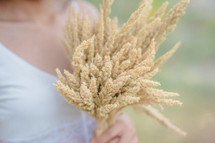 a woman holding wheat 