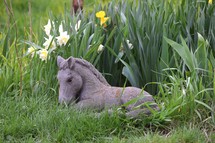 Horse statue in a flower garden in spring time.