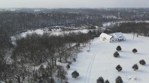 aerial view over a farmhouse in winter snow 