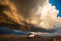 A Truck Passing Under Building Storm Clouds Full Of Sun Set Color