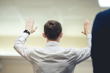 man with raised hands at church 
