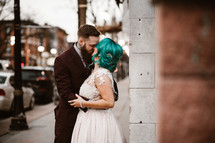 bride and groom kissing on a downtown sidewalk