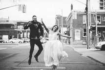 bride and groom in the middle of a street celebrating 