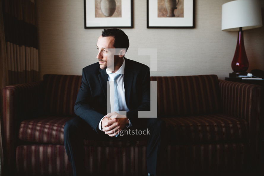 nervous groom sitting on a couch 