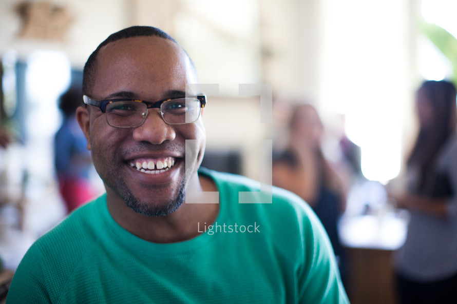 man smiling at a small group gathering 
