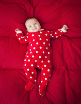 Newborn baby with Christmas suit with polka dot patterned.