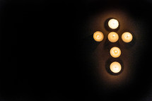 tea light candles in darkness - shape of a cross