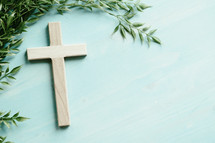 wood cross on a green wood background 