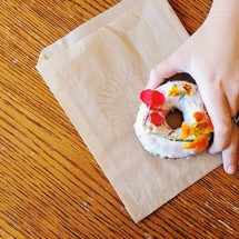 A hand picking up a donut.