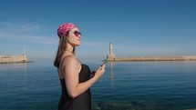 Woman tourist taking pictures and enjoying near lighthouse of Chania In Crete, Greece. 
