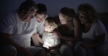 Big family and child with pad outdoor at night