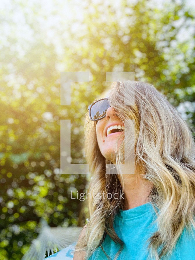 face of a smiling woman in sunglasses 