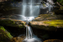 Waterfall cascading down mossy rocks long exposure