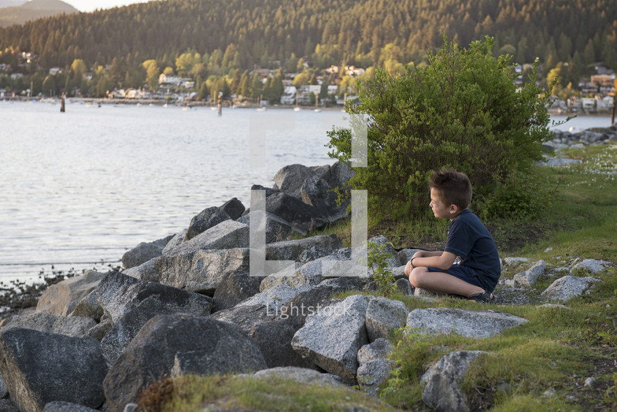 Little Boy Sitting On Shore Contemplating Life
