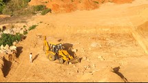 backhoe pushing rock and dirt 