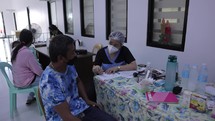 Asian Nurse Screening Patient For Covid