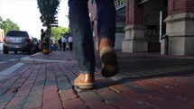 man walking down a brick sidewalk 