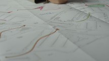 Close-up of Man’s hands drawing lines on the Large Format Paper at Modern Office. Architect using Ruler and Pencil to make Blueprints on Paper
