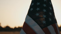 American flag in a field at sunset 
