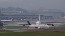 Slow motion of commercial airplanes moving down a taxiway at an airport.