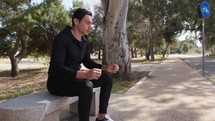 Pensive Man Sitting On A Bench At The Park