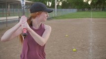 a woman hitting a softball 