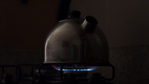 Kettle boiling on gas stove top - isolated