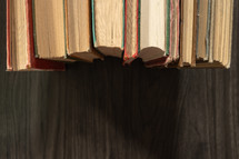 Border of vintage books on a dark wood table