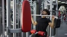 Young man exercising on lateral pull at gym - concept of bodybuilding, healthy routine.