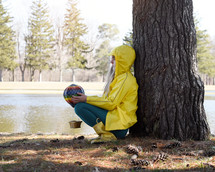 girl standing outdoors in rain boots and rain jacket 