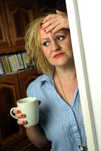 a woman holding a coffee mug thinking 