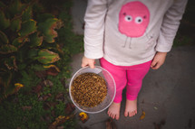 child with a bucket of meal worms 