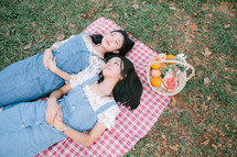 girls lying on a picnic blanket 