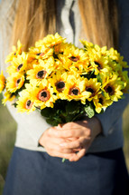Girl Holding bunch of yellow flowers